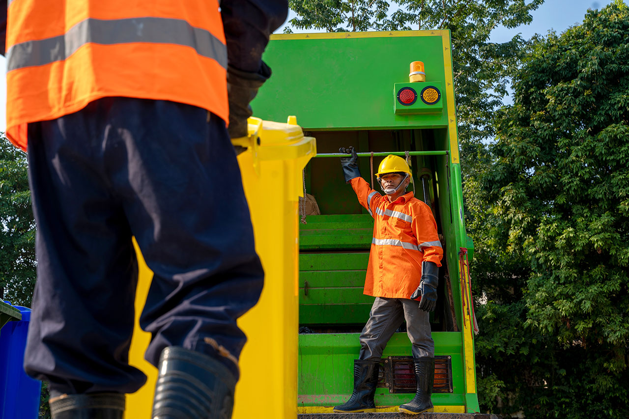 Garbage man working together on emptying dustbins for trash remo