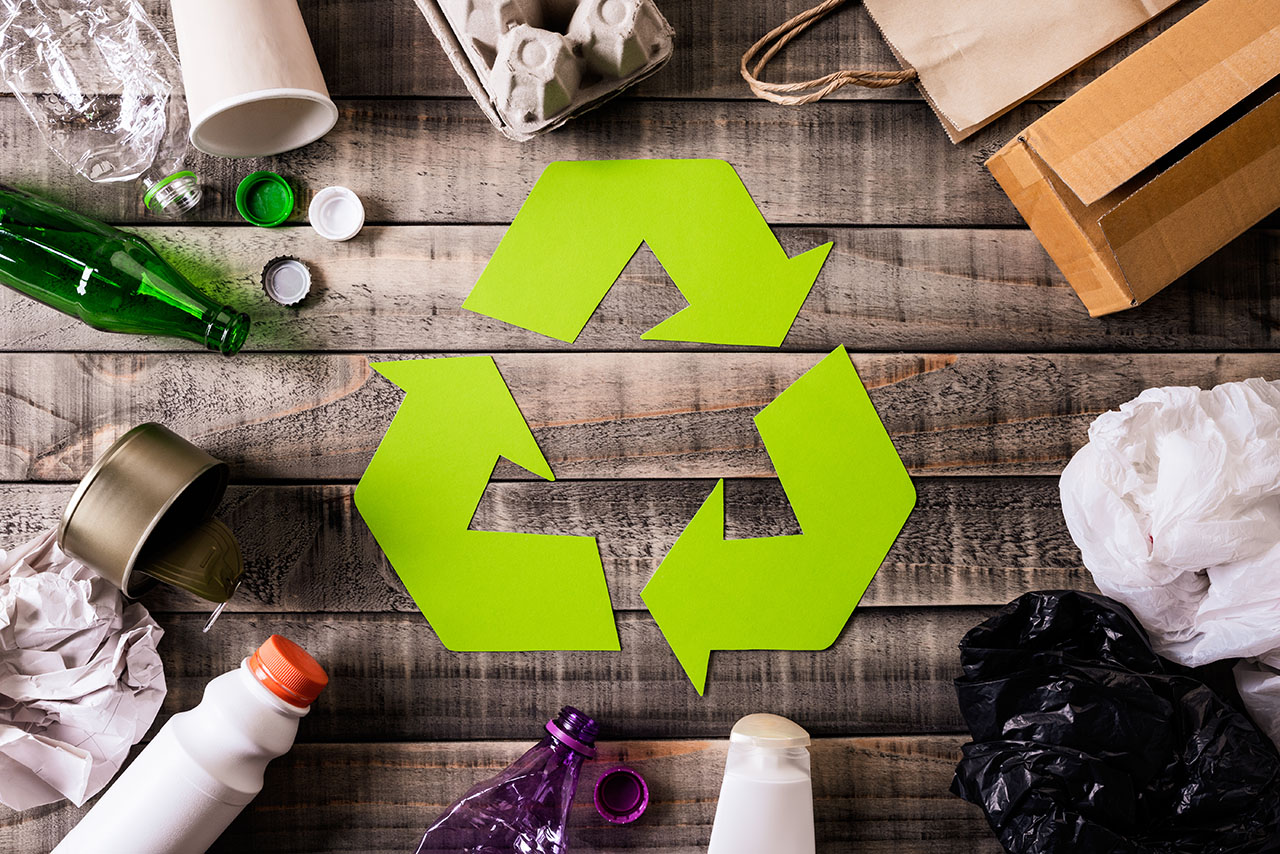 Top view of Different garbage materials with recycling symbol on